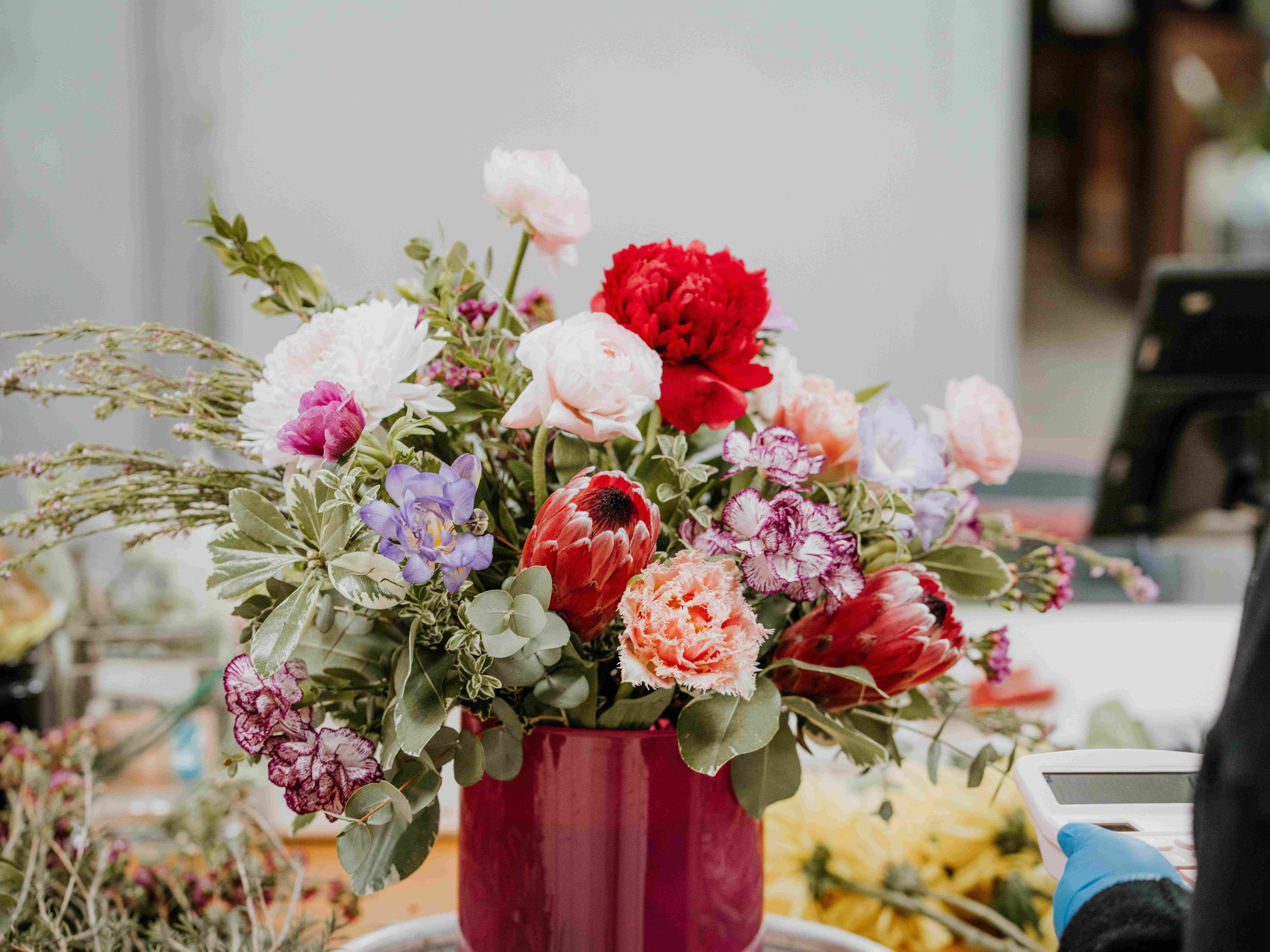 red, white, and lavender floral arrangement in a red vase
