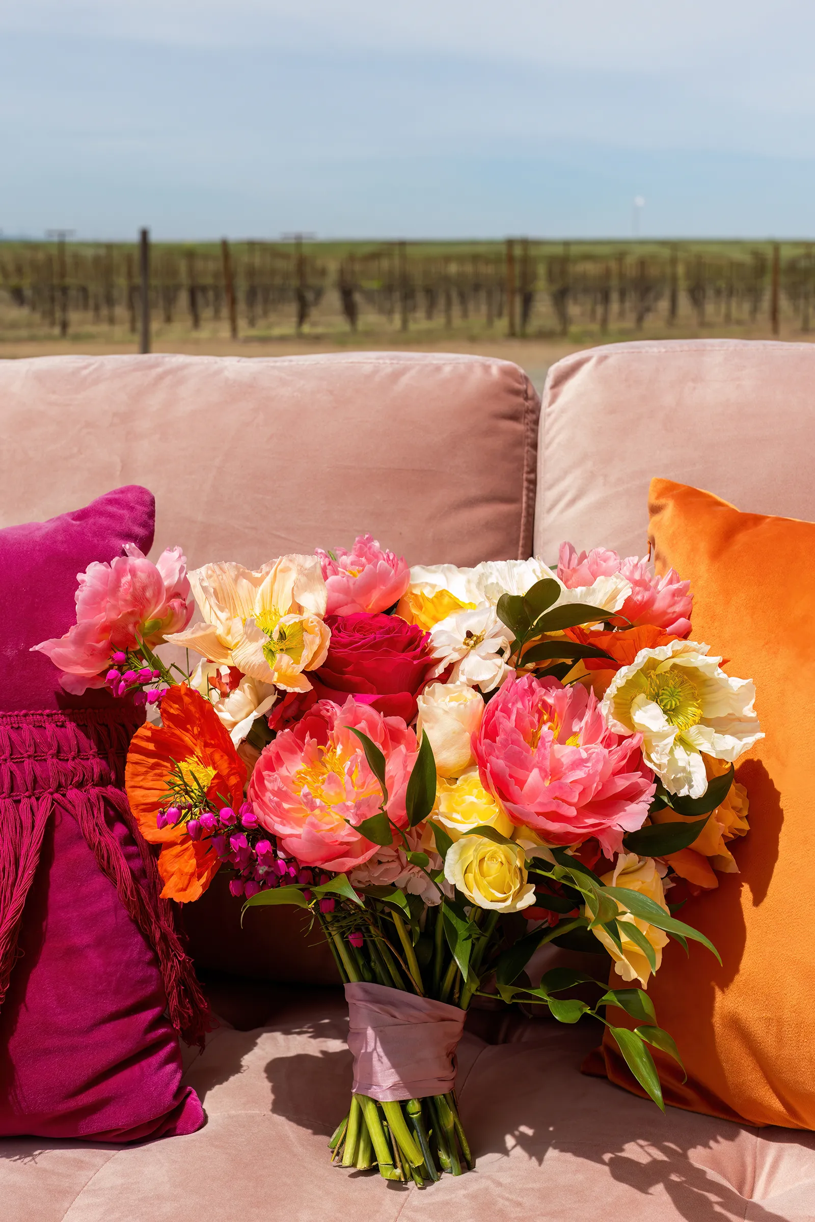 bridal bouquet with bright pink and orange peonies and roses