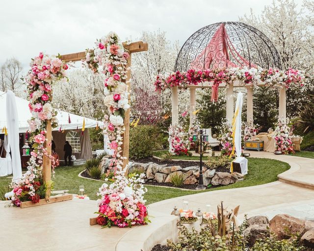outdoor wedding ceremony arch and pergola covered in pink and white flowers